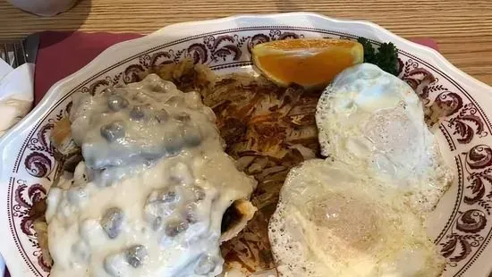 Homefries covered in sausage gravy with 3 eggs