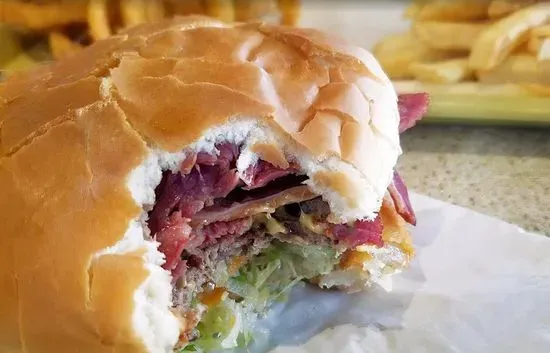 Bustrami w/ Fries - Succulent burger topped with grilled pastrami and swiss cheese, served with lettuce, tomato, onion, pickles, and mayo